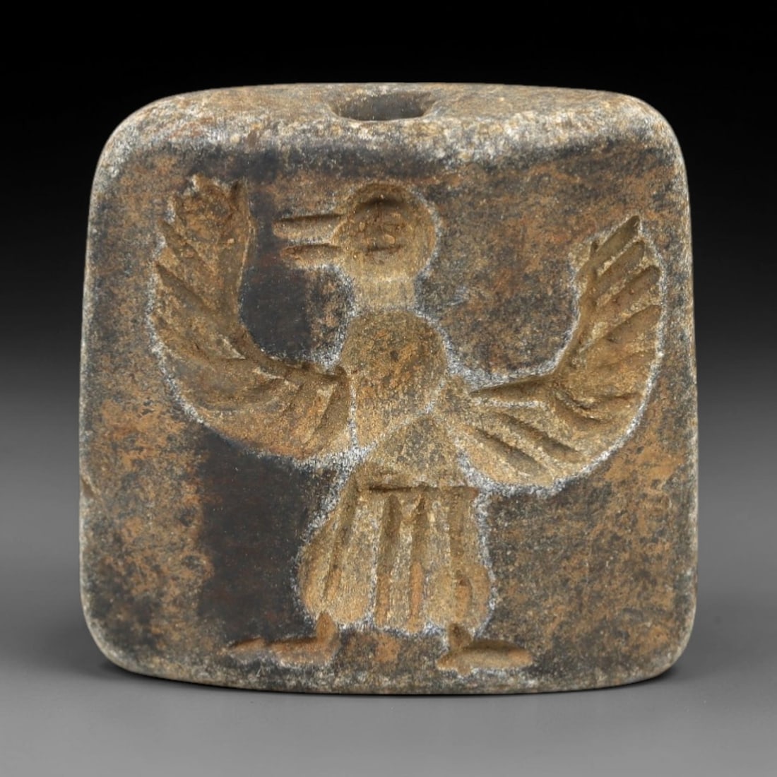 Ancient Schist Double Convex Bead Amulet - Near Eastern Avian Deity Intaglio, 80AM: Carved from dark gray schist, this 2.3x2cm double convex bead amulet features two distinct intaglio motifs: one side depicts a stylized avian deity with outstretched wings, anthropomorphic lower body