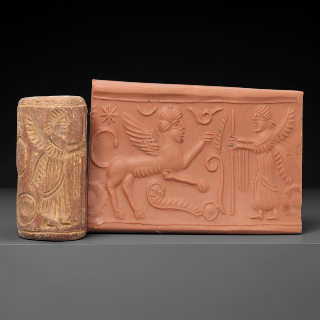 Ancient Steatite Cylinder Seal - Mesopotamian Sphinx & Winged Genius Apotropaic Scene, 24ZP: Carved from warm, earthy-toned steatite, this ancient Mesopotamian cylinder seal depicts a powerful apotropaic ritual scene, executed with precise glyptic craftsmanship characteristic of the Late Bron