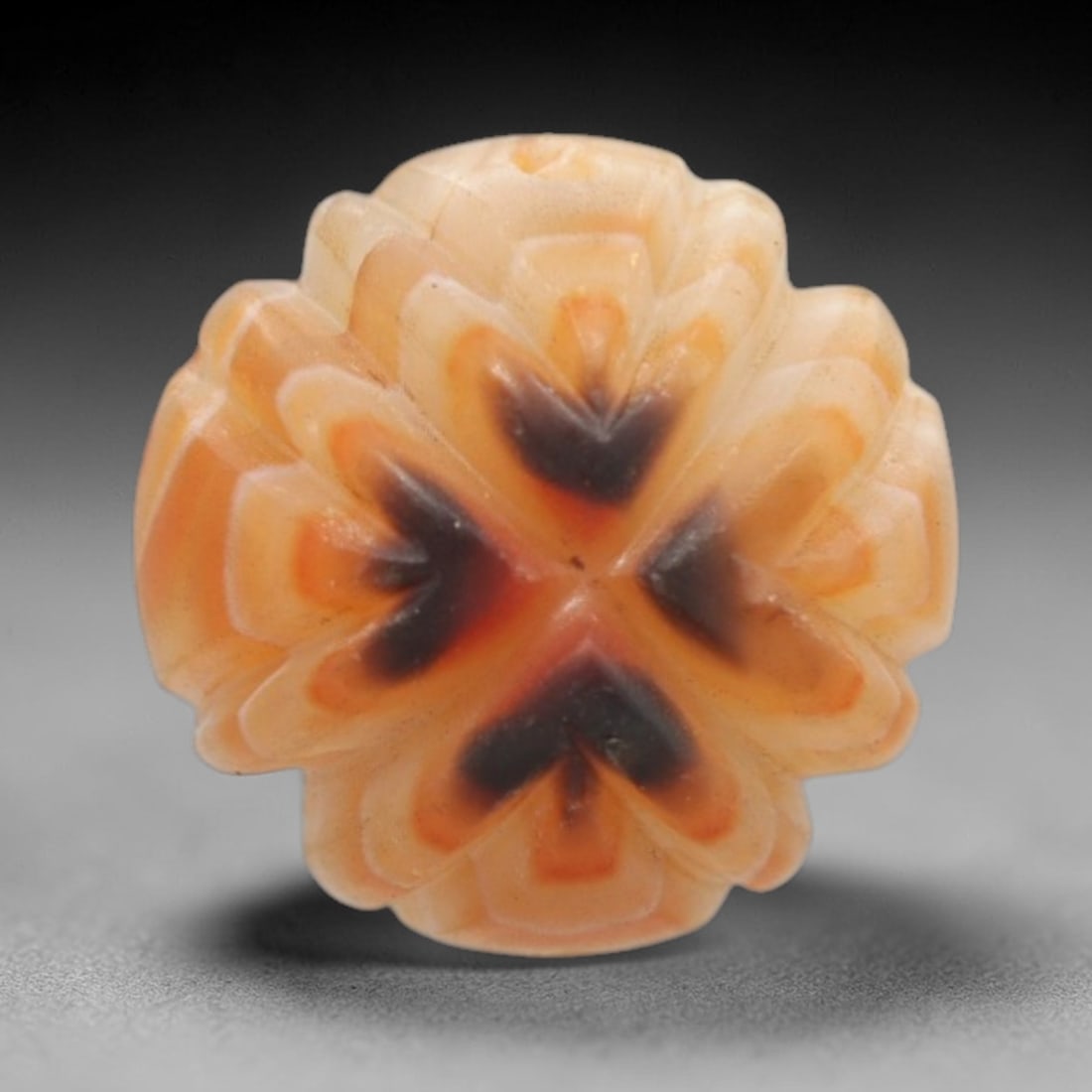 Antique Agate Floral Cross Bead - Central Asian Carved Gemstone, 18ZW: Carved from banded agate with warm peach-orange and creamy white banding, this bead features a symmetrical four-lobed floral form with a central cross motif accented by dark brown-black inclusions. A
