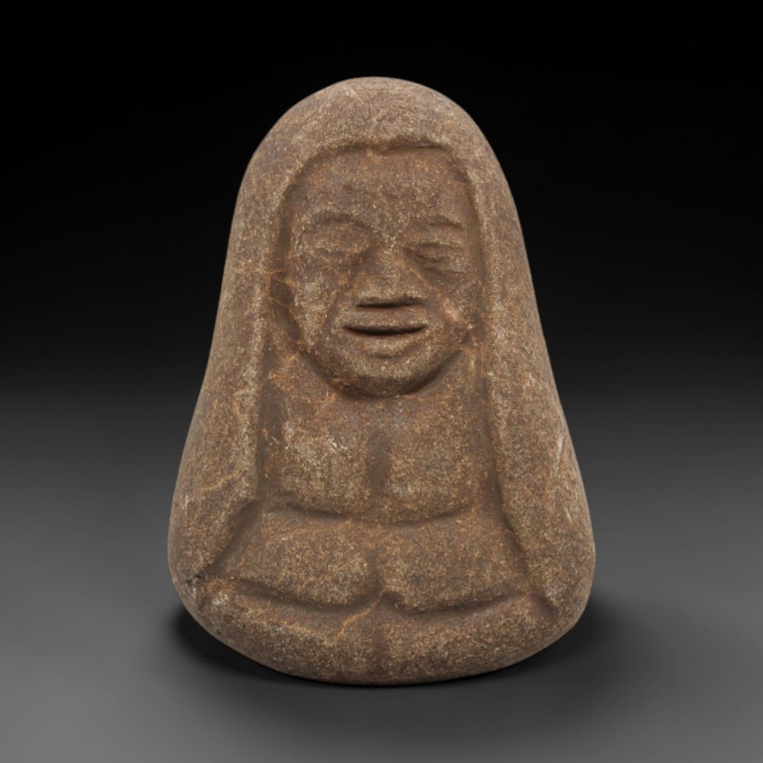 Ancient Style Stone Monk - Japanese Edo Figurine, 53FX: Carved from a single block of granular stone, this figure depicts a seated Edo-period monk in a compact, meditative form. The face is rendered with simplified, expressive features: closed eyes, a broa