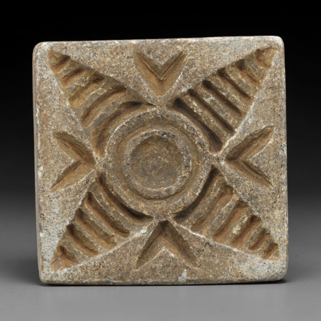 Ancient Greco-Bactrian Square Stone Stamp Seal - Solar Motif Artifact, 15ZR: This artifact is a square stone stamp seal, executed in the Greco-Bactrian decorative tradition of Central Asia. The face features a symmetrical solar motif: a central circular boss surrounded by conc