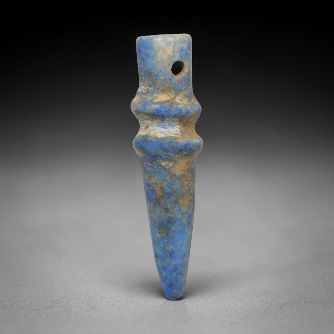 Ancient Lapis Lazuli Amulet - Egyptian Pointed Pendant, 21ZT: Carved from lapis lazuli, this amulet features a tapering, pointed form with a cylindrical upper lug pierced for suspension, its body marked by two raised horizontal bands that define its segmented st