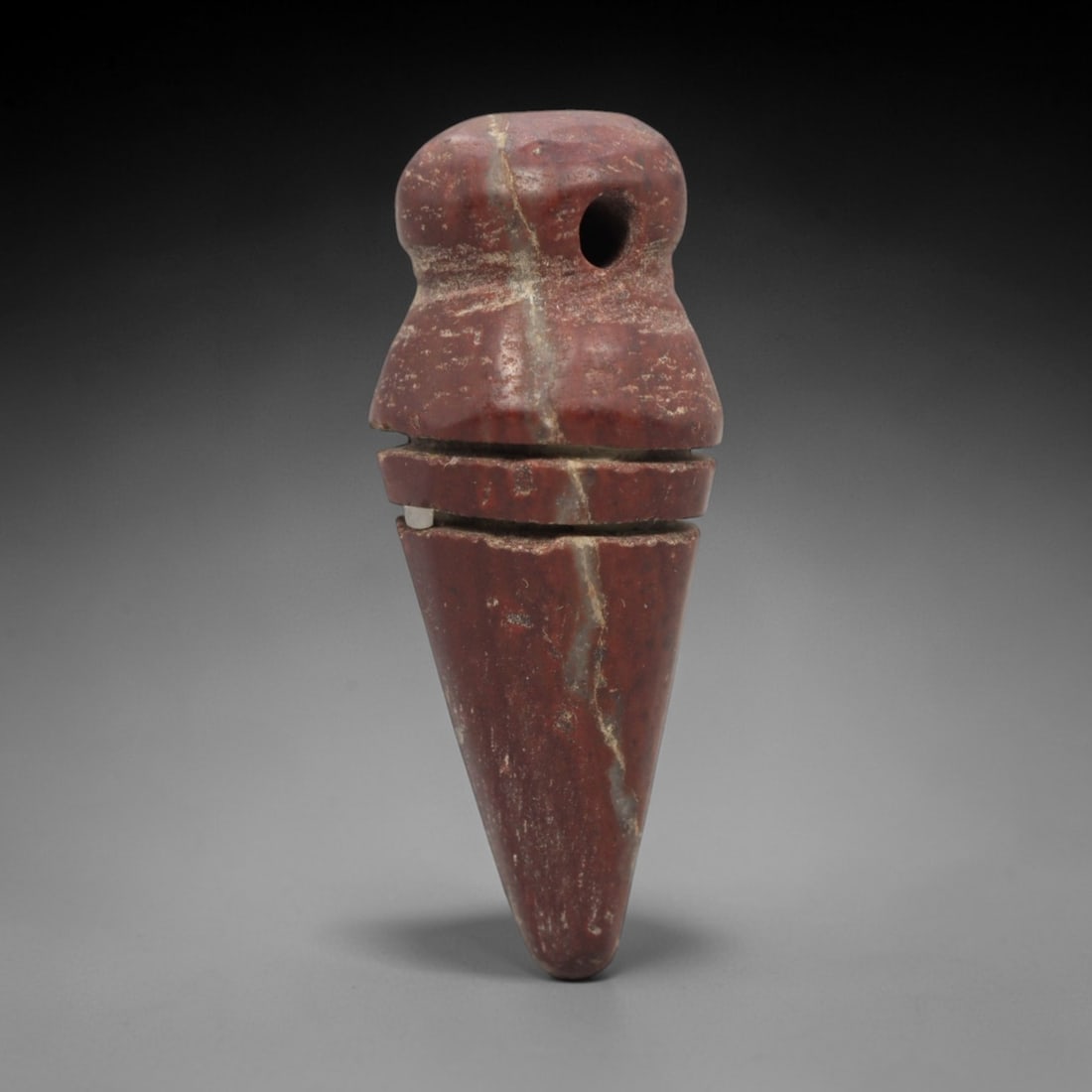Ancient Near Eastern Red Stone Conical Amulet - Carved Pendant Figure, 23ZV: This amulet is carved from a rich, deep red stone with natural white veining, likely brecciated jasper, featuring a robust segmented conical form. The piece consists of a rounded suspension loop with
