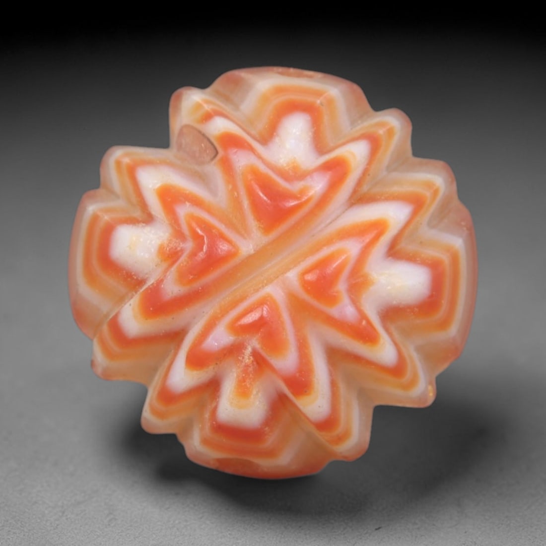 Antique Agate Star Bead - Central Asian Carved Gemstone, 15AR: Carved from banded agate with warm orange and creamy white concentric banding, this bead features a symmetrical multi-pointed star form with scalloped, layered edges. A lateral perforation confirms it