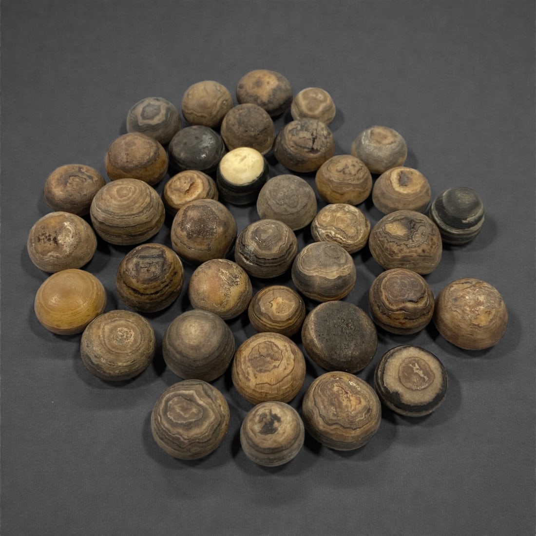 A Group of Tibetan Luk Mik ("Goat's Eye") Agate Beads, 19th-20th Century, 37V: Comprising thirty-seven spherical and near-spherical beads carved from agate, the group is characterized by pronounced concentric banding and circular "eye" formations known as Luk Mik ("goat's eye"),