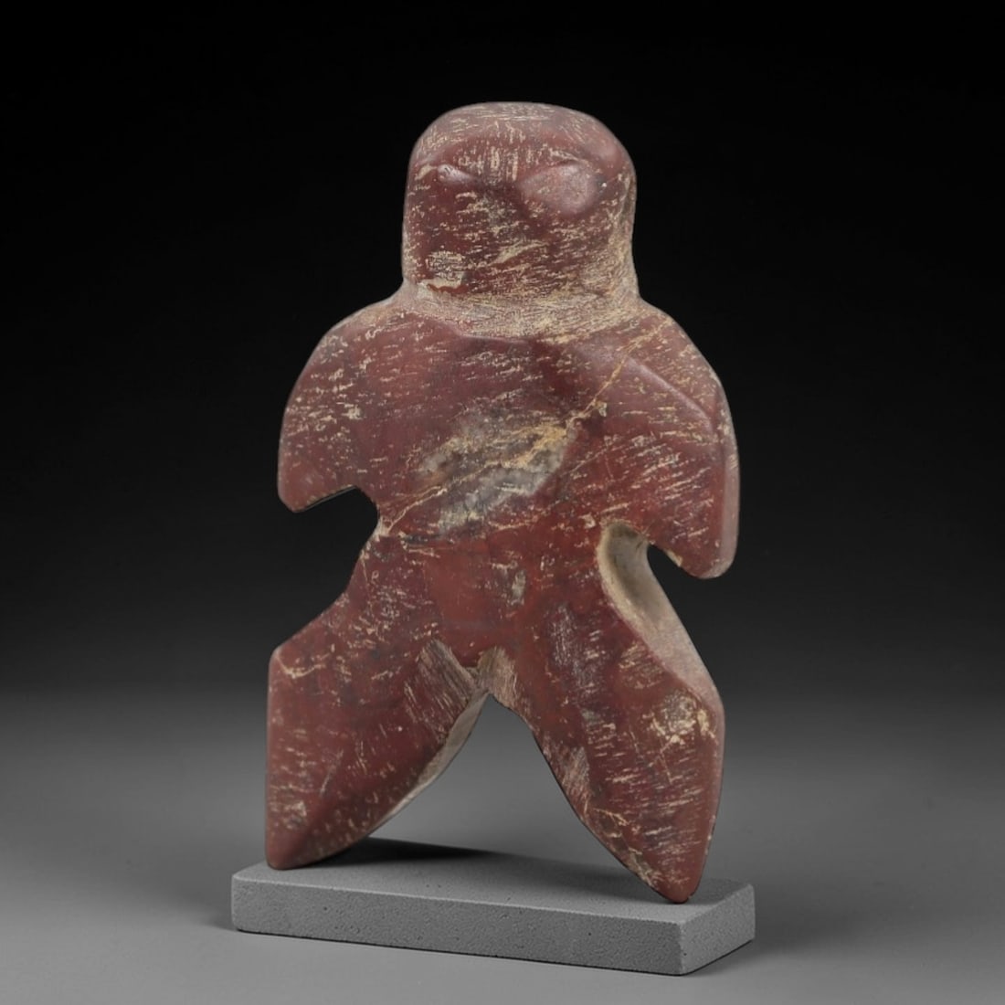Ancient Egyptian Stone Amulet - Carved Ritual Figurine, 54AE: Carved from reddish-brown stone, this amulet features a stylized humanoid form with incised linear detailing, consistent with ancient Egyptian ritual amulets of the Late Period. The piece has a suspen