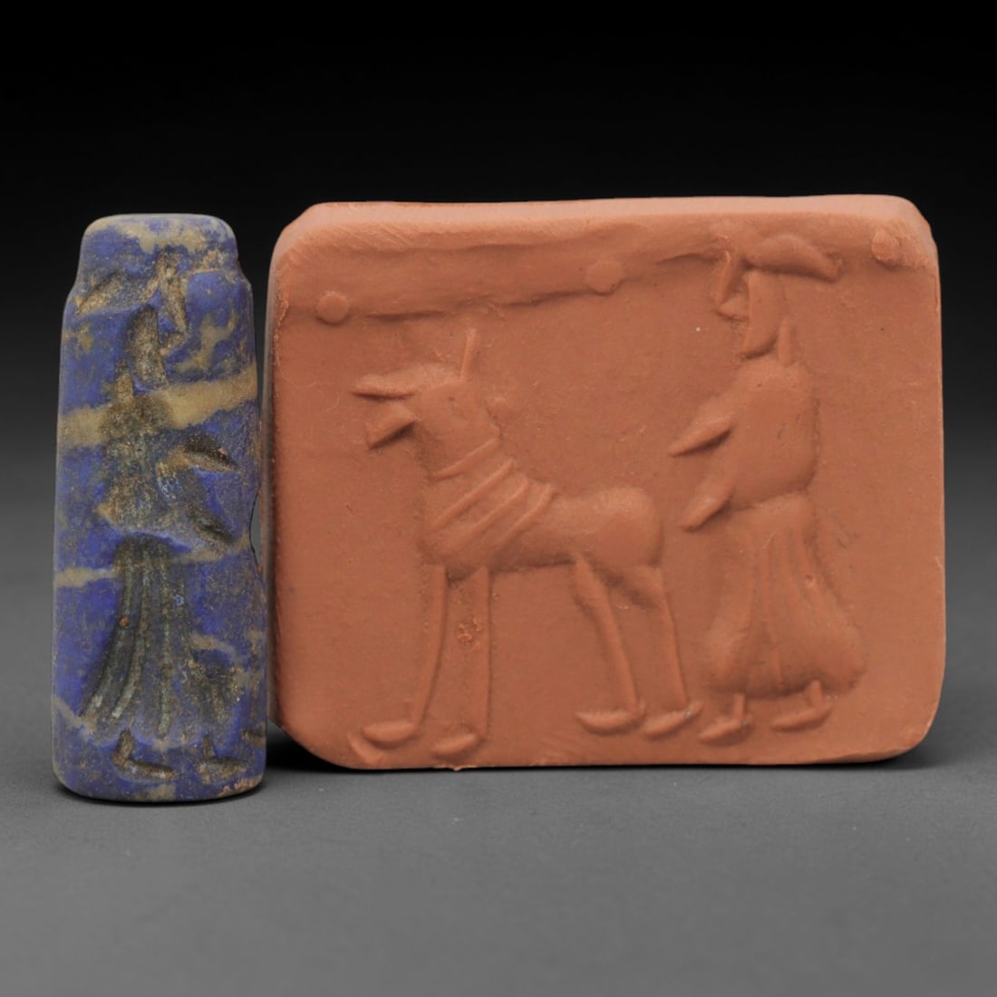 Ancient Lapis Lazuli Cylinder Seal - Near Eastern Glyptic Art, 50ZQ: Carved from lapis lazuli stone, this ancient Near Eastern cylinder seal features a cylindrical form with raised relief carvings depicting a stylized human figure with detailed linear patterns. The sea