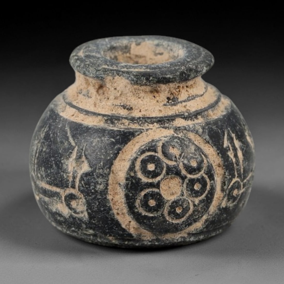 Ancient Bone Spindle Whorl - Near Eastern Geometric Motif, 90AH: This ancient Near Eastern spindle whorl is carved from bone, featuring a convex form with a central perforation. The surface is incised with a combination of circular and linear geometric motifs, a co