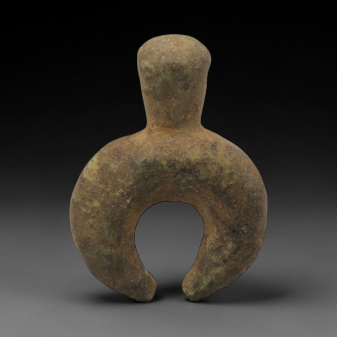 Ancient Stone Crescent Amulet - Near Eastern Protective Pendant, 11XR: Carved from mottled greenish-brown stone, this amulet features a stylized form with a rounded upper section and a crescent-shaped lower body. The geometric, symbolic design is characteristic of Ancien