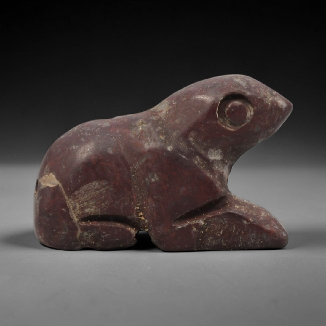 Ancient Near Eastern Red Stone Hare Amulet - Carved Figurine, 10ZV: This amulet is carved from a rich, deep red stone with natural mineral veining and patination, likely brecciated jasper or red steatite, featuring a stylized recumbent hare (or rabbit) form. The piece