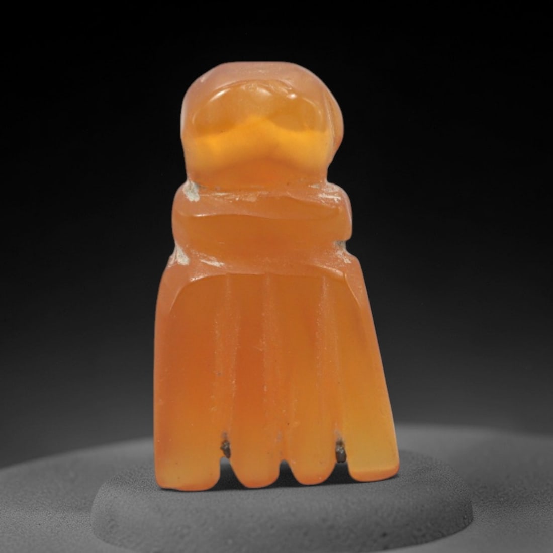 Ancient Carnelian Fist - Egyptian Protective Amulet, 79XS: Carved from translucent carnelian with warm amber hues and subtle surface inclusions, this amulet takes the form of a clenched fist, rendered in a stylized, upright configuration characteristic of anc