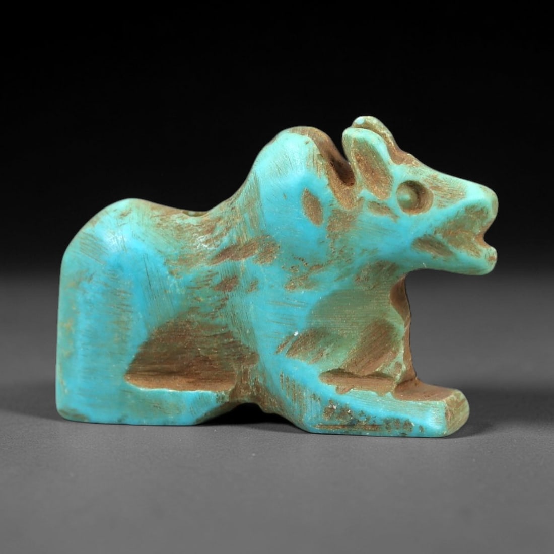 Ancient Turquoise Recumbent Animal Amulet - Near Eastern Ritual Pendant, 43AN: Carved from turquoise, this amulet depicts a stylized recumbent animal (likely a gazelle or ibex) with distinct ears, a defined snout, and a compact, crouched posture. The vibrant turquoise stone exhi