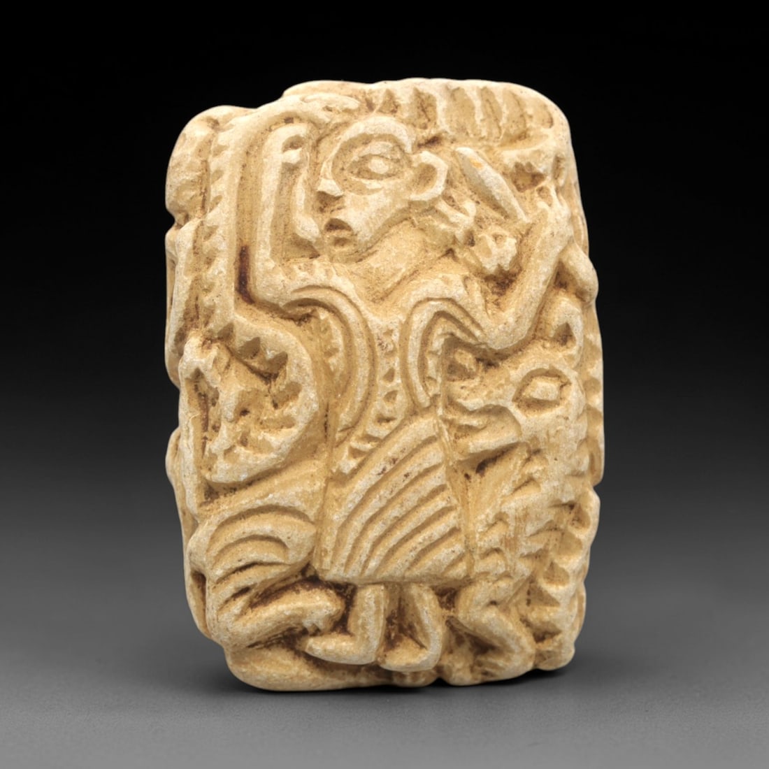 Ancient Stone Double Convex Amulet Bead - Near Eastern Figurine, 30ZS: This artifact is a carved stone double convex amulet bead featuring intricate anthropomorphic iconography, crafted in the glyptic tradition of the ancient Near East. The bead's form is defined by rais