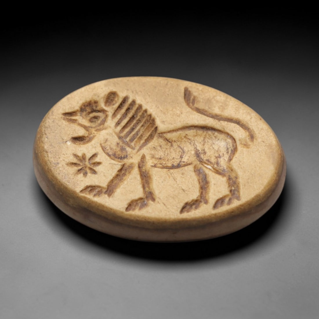 Ancient Agate Intaglio Bead - Near Eastern Lion Motif, 33ZW: Carved from warm banded agate, this oval intaglio bead features a recessed depiction of a striding lion with a curled tail, accompanied by a star-like geometric motif, characteristic of ancient Near E