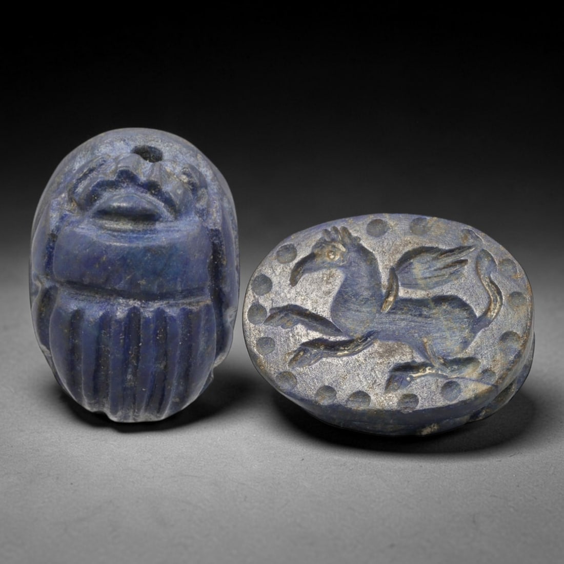 Ancient Lapis Lazuli Scarab - Near Eastern Griffin Seal, 74AS: This artifact is hand-carved from lapis lazuli, employing traditional ancient lapidary techniques consistent with Near Eastern Bronze Age seal craftsmanship. The object takes the form of a scarab beet