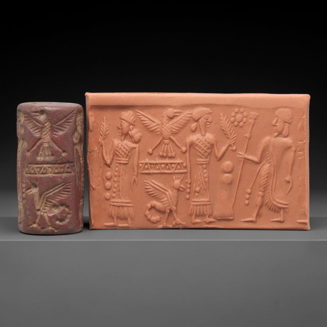 Ancient Steatite Cylinder Seal - Mesopotamian Royal Procession & Winged Deity Scene, 56AL: Carved from rich, reddish-brown steatite, this ancient Mesopotamian cylinder seal depicts a formal royal procession scene, executed with meticulous glyptic craftsmanship characteristic of the Neo-Assy