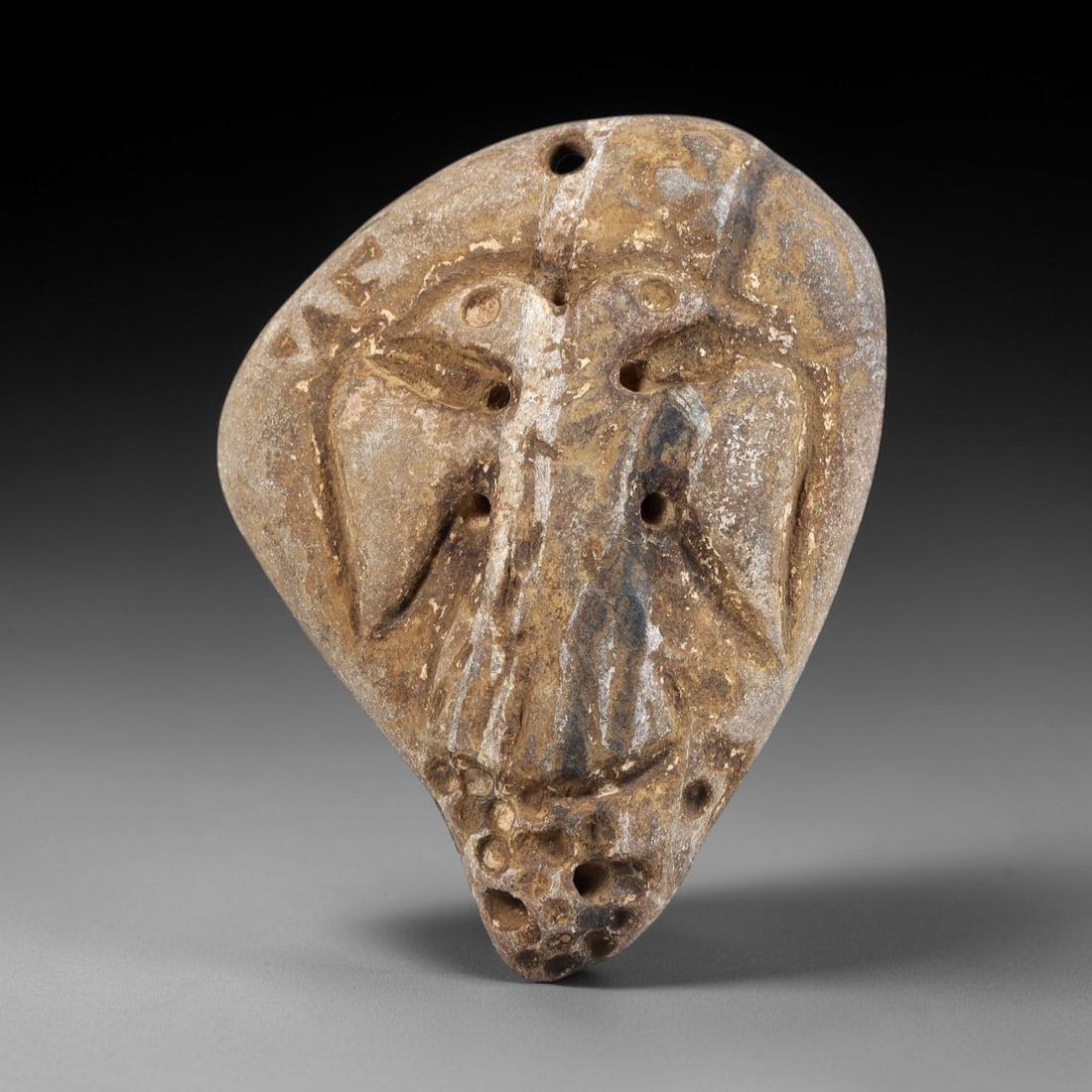 Ancient Stone Amulet - Near Eastern Double-Headed Bird, 1FY: Carved from a naturally weathered stone, this amulet features a bas-relief depiction of a double-headed bird, with the heads facing outwards and sharing a central body with stylized wings. Incised lin