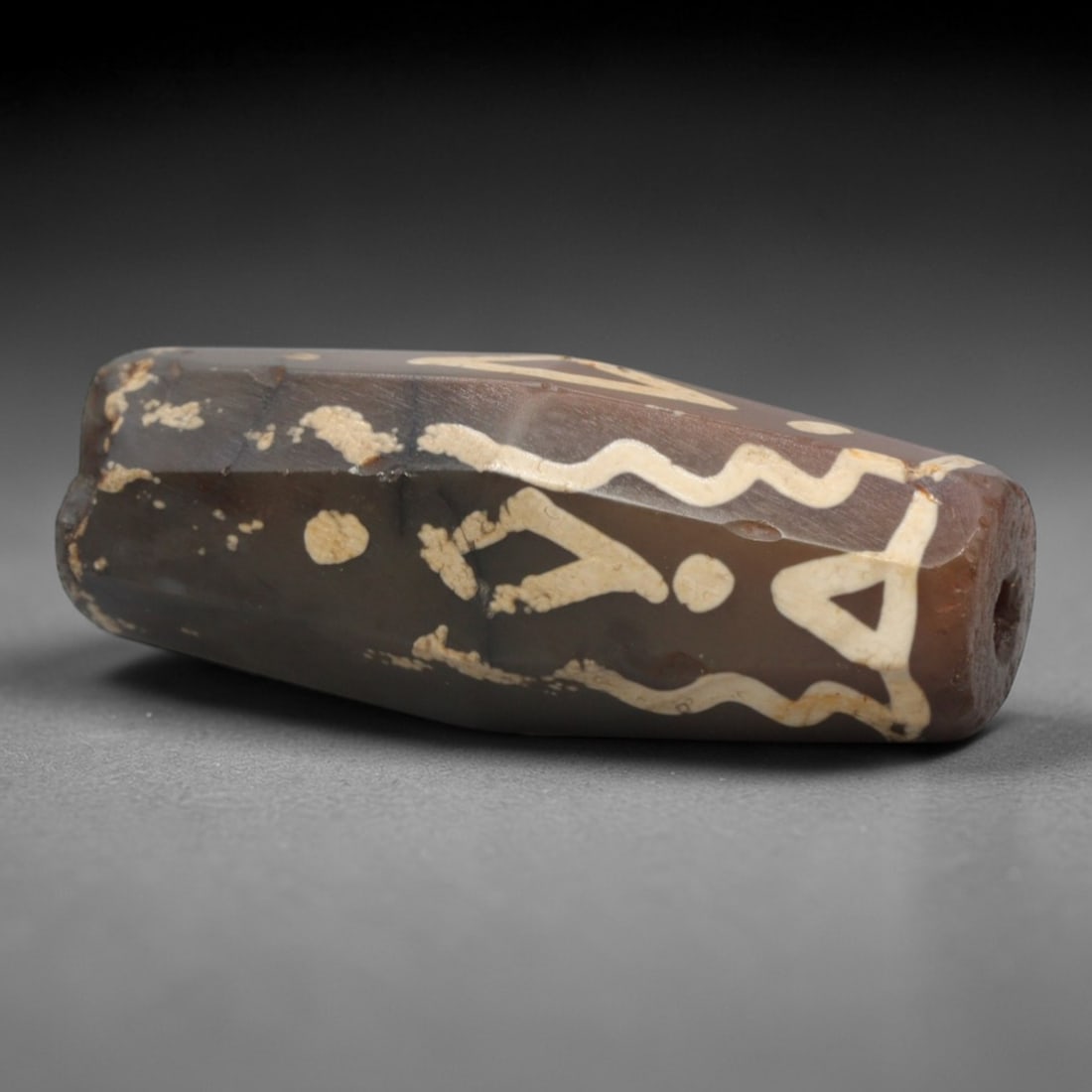 Ancient Agate Etched Dzi Bead - Himalayan Amulet, 79XV: Crafted from dark banded agate, this faceted bead features etched symbolic motifs including wavy lines, triangular forms, and circular dots, executed in traditional Himalayan Dzi bead techniques. The