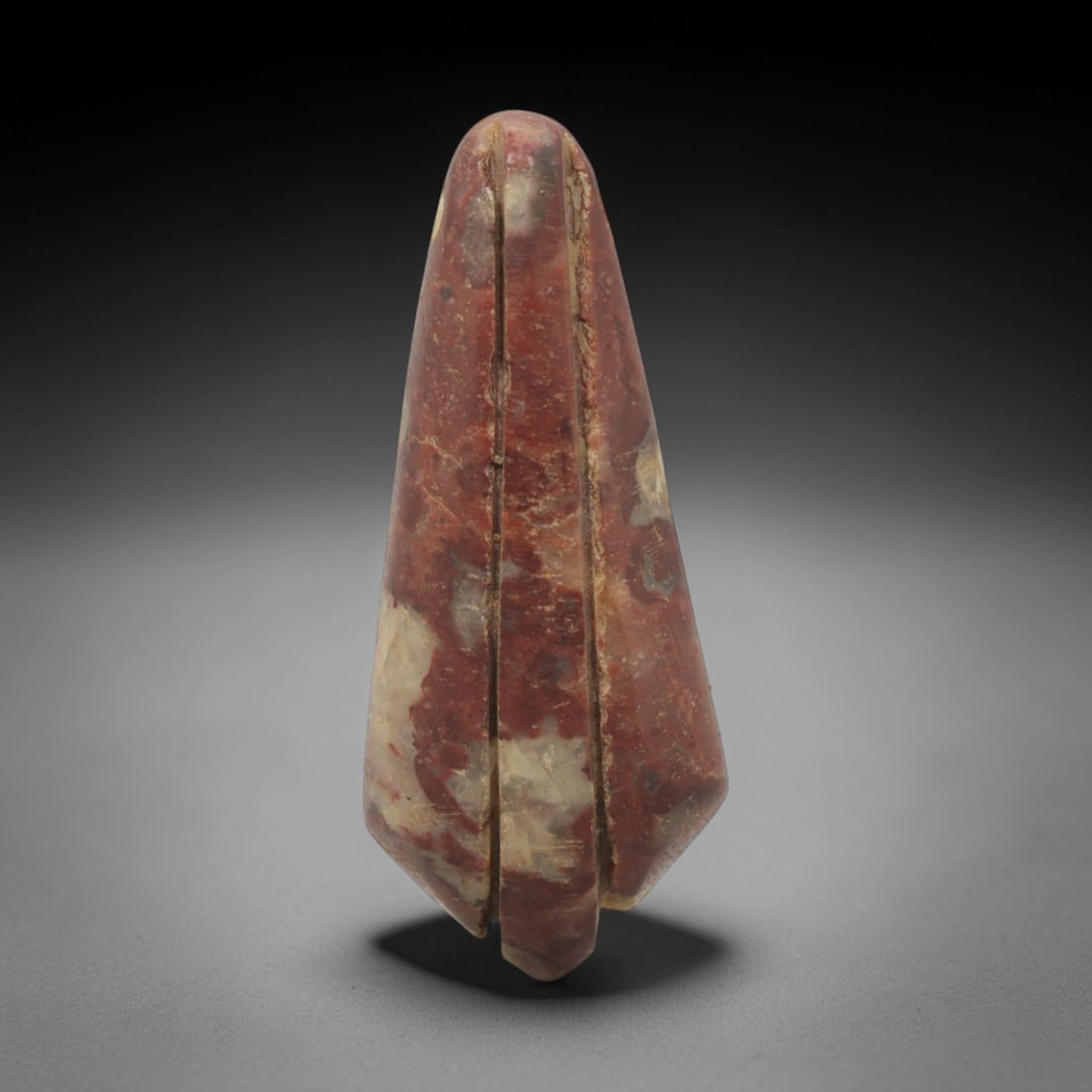 Ancient Stone Leaf Amulet - Near Eastern Ritual Pendant, 80XQ: Carved from a variegated reddish-brown stone with pale inclusions, this amulet exhibits an elongated teardrop-leaf form with a rounded apex and faceted base. Two parallel vertical incisions run the fu