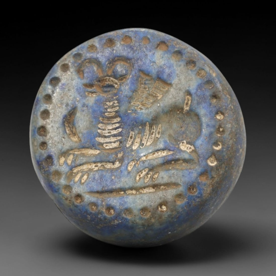 Ancient Lapis Stamp Seal - Near Eastern Caprine Figure, 67ZR: Carved from deep blue lapis lazuli, this hemispherical stamp seal features a raised relief depiction of a recumbent caprine (likely ibex or ram), alongside stylized linear motifs and a border of raise
