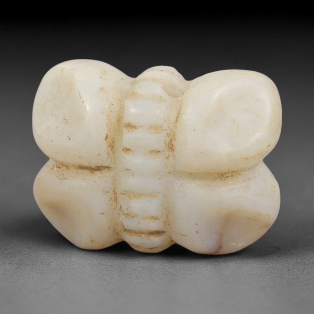 Ancient Chalcedony Fly Amulet - Egyptian Figurine, 71AR: This artifact is carved from pale, milky-white chalcedony, exhibiting a smooth, matte finish with subtle surface discoloration and mineral inclusions consistent with age. The form is a stylized fly am