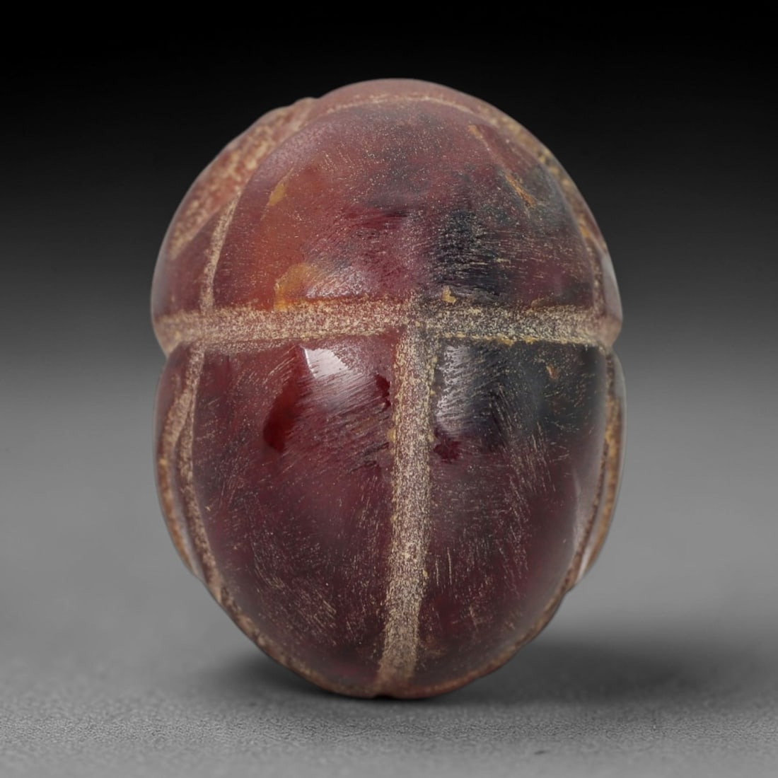 Ancient Banded Agate Scarab Amulet - Egyptian Figurine, 28XS: Carved from striking banded agate with deep crimson-red, amber-orange, and dark charcoal natural inclusions, this amulet is formed as a stylized scarab beetle with incised linear detailing to define a