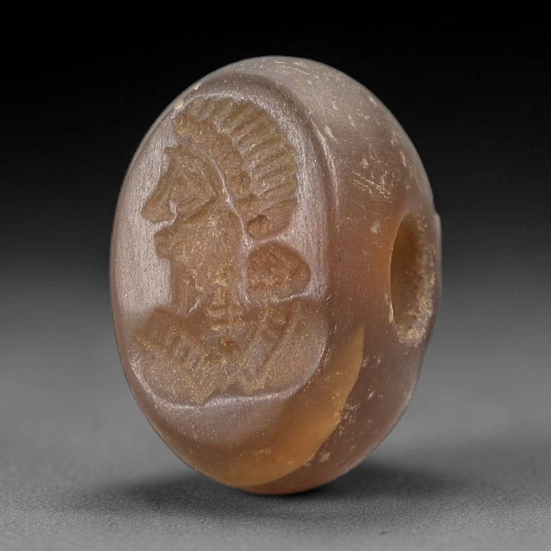 Ancient Chalcedony Hemispherical Stamp Seal - Near Eastern Deity Amulet, 32AN: This ancient Near Eastern hemispherical stamp seal is carved from translucent, warm brown chalcedony, with a smooth, subtly frosted patina consistent with ancient handling. The seal's oval face depict