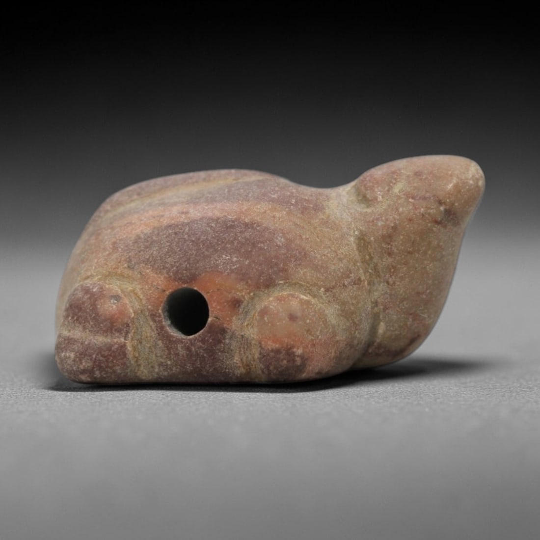 Ancient Red Stone Turtle Amulet - Egyptian Animal Figure, 75ZW: This amulet is carved from mottled red and cream stone, depicting a stylized seated turtle with a rounded carapace and subtle incised lines defining the head, limbs, and shell texture. The form is com