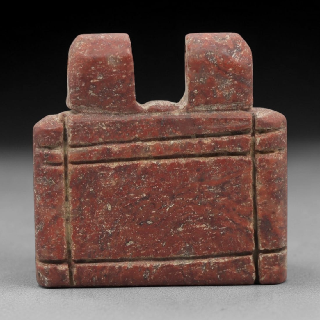 Ancient Near Eastern Red Stone Shrine Amulet - Carved Pendant Figure, 30ZV: This amulet is carved from a rich, reddish-brown stone with natural speckling, likely brecciated jasper or red steatite, with incised linear details defining its stylized shrine form. The piece featur