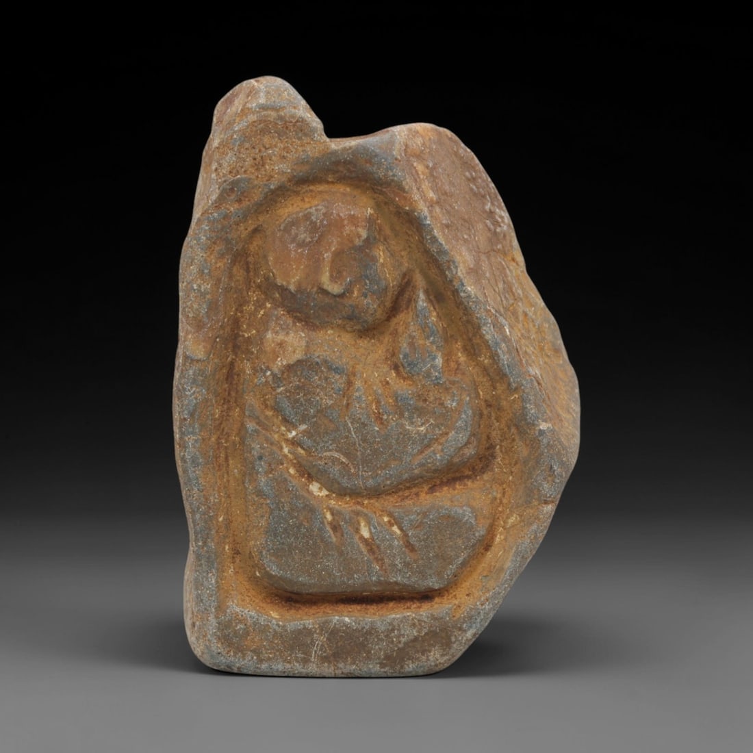 Ancient Stone Edo Monk - Japanese Buddhist Figurine, 92FW: Carved from a weathered, multi-tonal stone with earthy-brown patina and natural mineral veining, this artifact depicts a seated Edo-period Buddhist monk in low relief, framed by the rough, organic edg