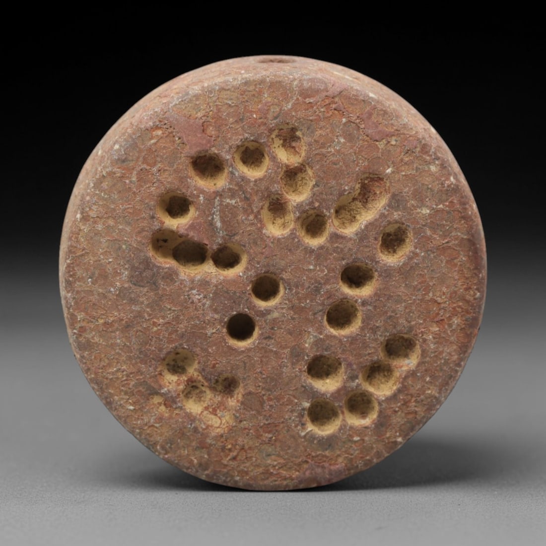 Ancient Limestone Double-Convex Seal - Mesopotamian Carved Bead, 63ZQ: Carved from limestone, this ancient Mesopotamian double-convex seal bead features a raised relief geometric and dot-and-circle pattern on the convex surface, typical of small administrative or ritual