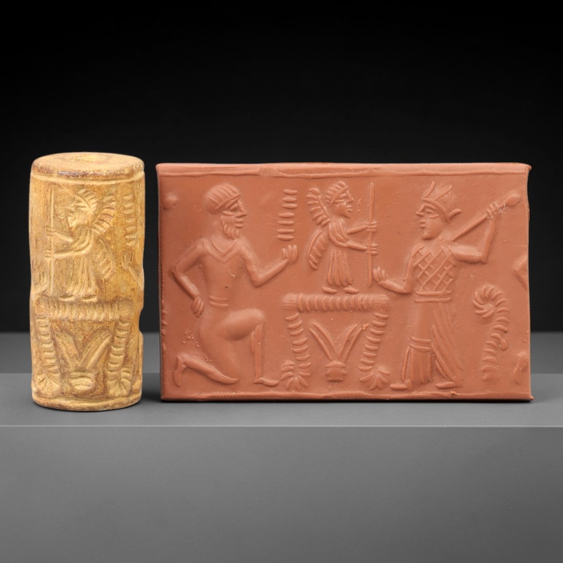 Ancient Steatite Cylinder Seal - Mesopotamian Figural & Winged Deity Scene, 71AN: Carved from dense steatite, this ancient Mesopotamian cylinder seal features a detailed linear relief composition of human figures and a central winged deity, executed in the characteristic glyptic st