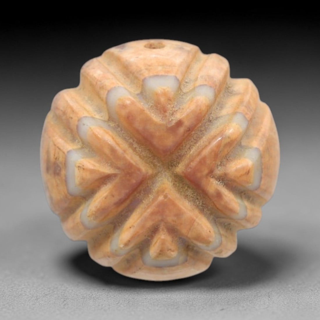 Antique Agate Star Bead - Central Asian Carved Gemstone, 11ZW: Carved from banded agate with a warm peach-tan base and creamy white edge inclusions, this bead features a symmetrical four-pointed star motif with deeply carved, layered chevron ridges. A top perfora