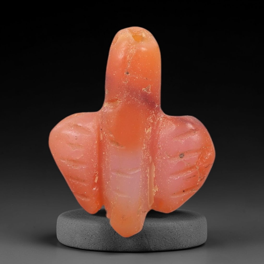 Ancient Agate Fly - Egyptian Amulet Pendant, 43XS: This amulet is carved from translucent orange-red agate, exhibiting natural banding and a warm hue characteristic of ancient Egyptian glyptic craftsmanship. The form is a stylized fly, with a segmente