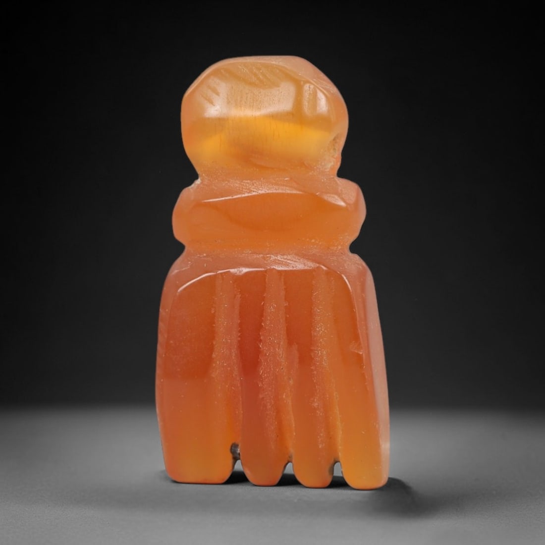 Ancient Carnelian Fist Amulet - Egyptian Figurine, 17AJ: Carved from warm orange carnelian, this amulet is formed as a stylized clenched fist with a rounded upper segment and four distinct finger projections, consistent with ancient Egyptian protective amul