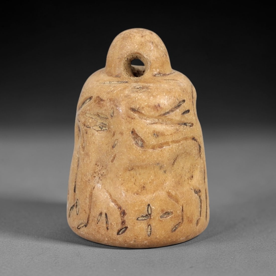 Ancient Bell-Shaped Stone Stamp Seal - Near Eastern Zoomorphic Impression, 33AM: This bell-shaped stamp seal is carved from a pale, granular stone with a warm earthy patina, exhibiting subtle surface striations and natural mineral inclusions. The form features a rounded, pierced s
