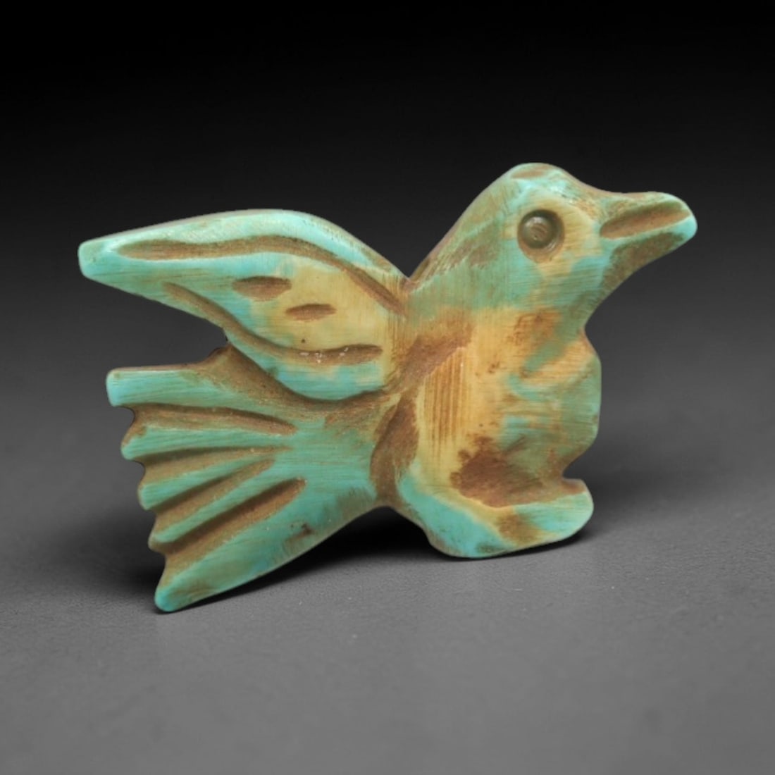 Ancient Turquoise Bird Amulet - Egyptian Animal Figurine, 21ZS: This artifact is a carved turquoise bird amulet, crafted in the stylized zoomorphic tradition of ancient Egypt. The amulet depicts a bird in flight with simplified yet distinct anatomical features, in