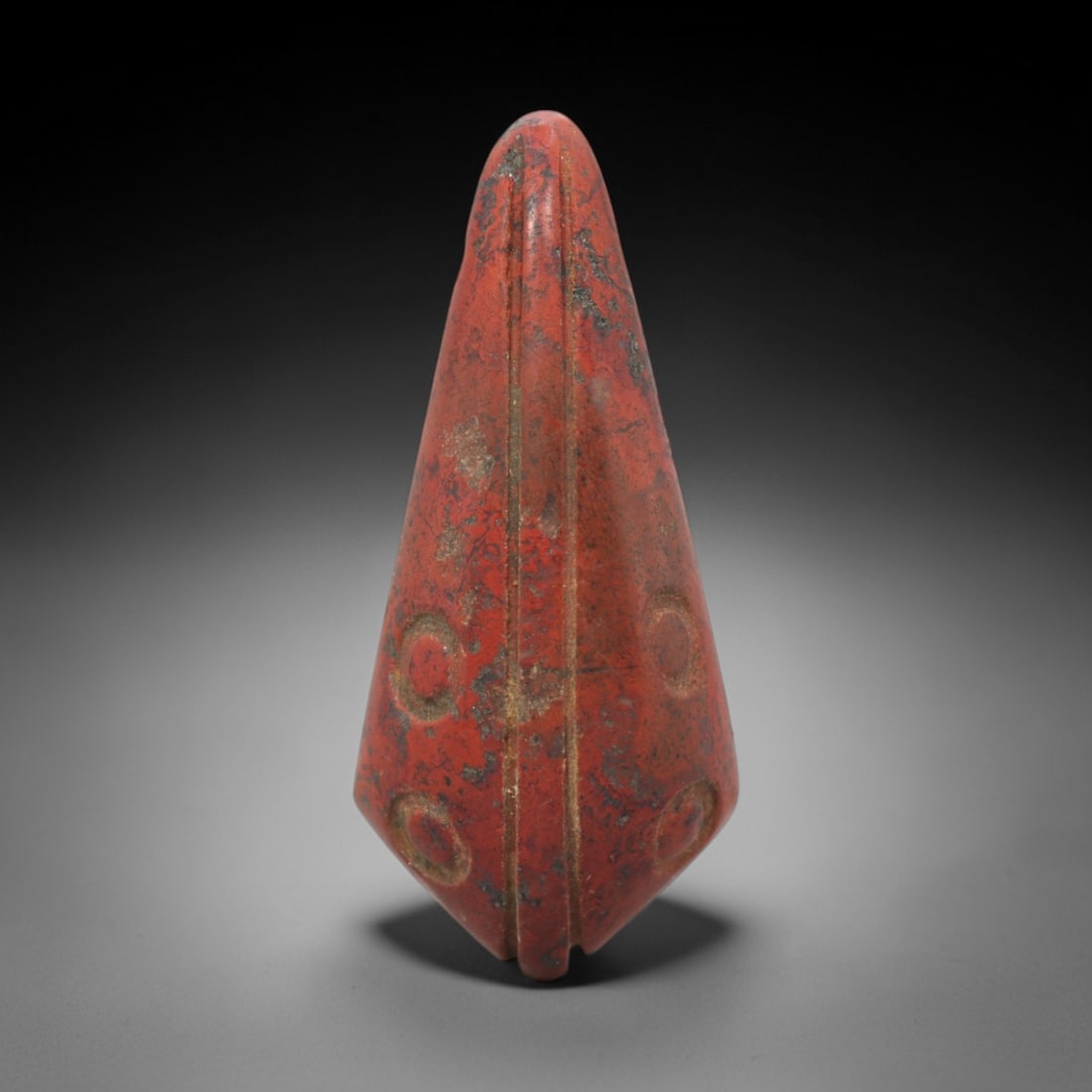 Ancient Near Eastern Red Stone Spearhead Amulet - Carved Pendant Figure, 44ZV: This amulet is carved from a rich, deep red stone with natural mineral inclusions and patination, likely brecciated jasper or hematite, featuring a striking spearhead form. The piece is defined by a c