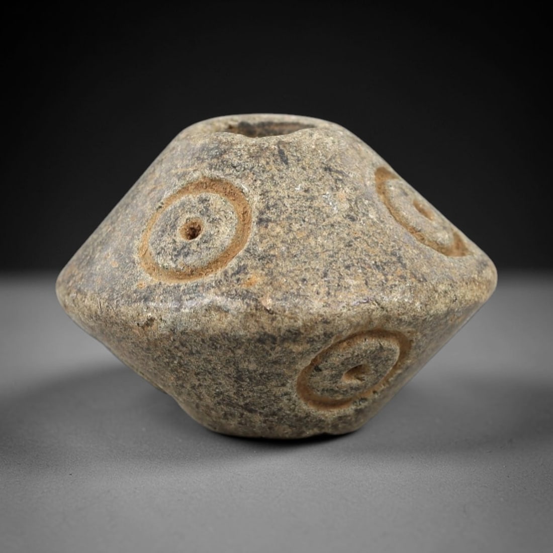 Ancient Schist Polyhedral Bead - Near Eastern Ritual Pendant, 71AK: Carved from speckled gray schist, this faceted bead features a symmetrical multi-sided form with raised circular motifs (each with a central dot) across its surfaces, characteristic of Near Eastern Br