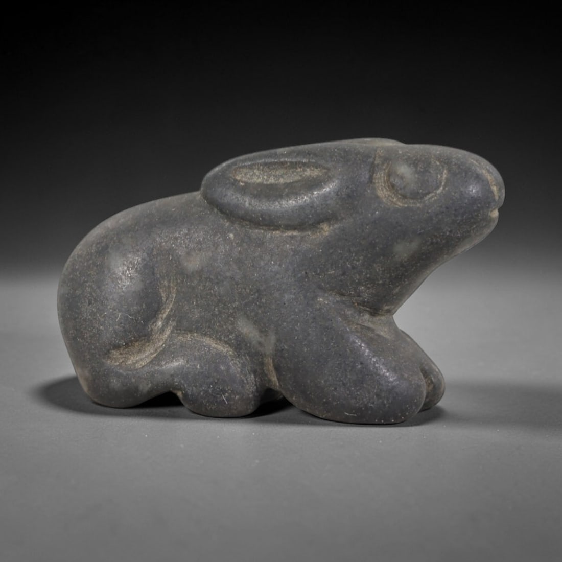Ancient Stone Hare - Near Eastern Animal Figurine, 31AP: This artifact is carved from dark gray stone with a matte, weathered patina and subtle surface wear, exhibiting simplified, stylized features consistent with ancient Near Eastern animal iconography. T