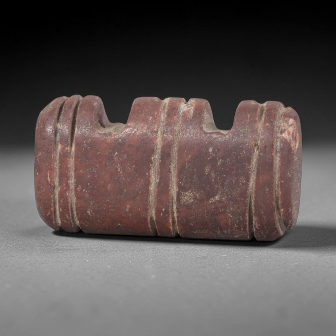Ancient Stone Amulet - Egyptian Ritual Pendant, 85AP: This artifact is carved from deep red stone with a weathered, earthy patina and subtle mineral inclusions, exhibiting precise incised linear detailing consistent with ancient Egyptian stoneworking tec
