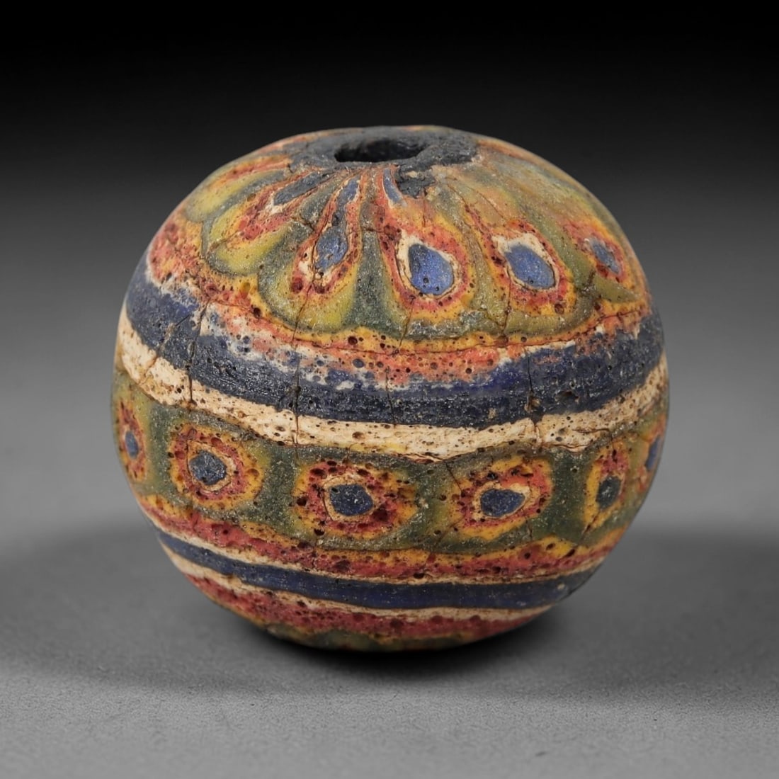 Ancient Glass Eye Bead - Egyptian Amulet Bead, 44ZM: This ancient bead is crafted from polychrome glass, formed using core-formed and trailed decorative techniques characteristic of Egyptian glassworking traditions. The spherical form features multiple