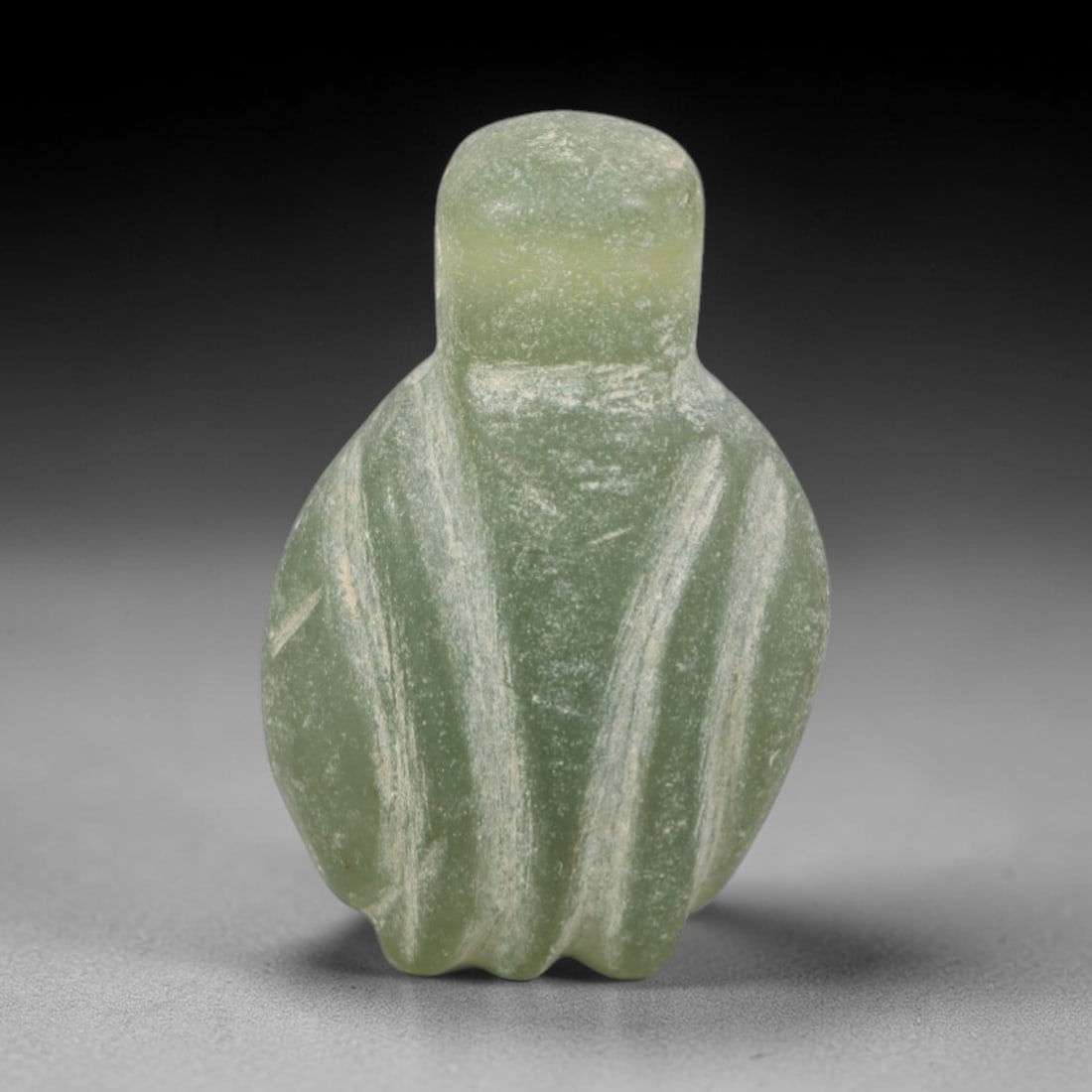 Ancient Green Stone Bird Amulet - Near Eastern Figurine, 51AR: This artifact is carved from pale, translucent green stone, exhibiting a smooth, matte finish with subtle natural inclusions and faint surface wear consistent with age. The form is a stylized bird amu