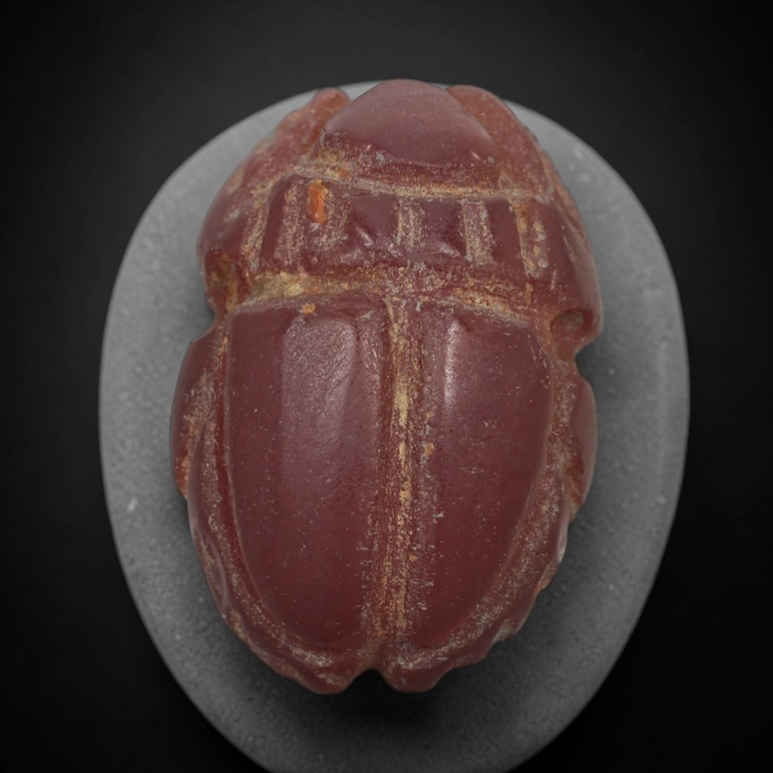 Ancient Red Jasper Scarab Amulet - Egyptian Figurine, 56AJ: Carved from deep red jasper, this amulet is formed as a stylized scarab beetle with incised linear detailing across the segmented body and wing cases, consistent with ancient Egyptian funerary amulet