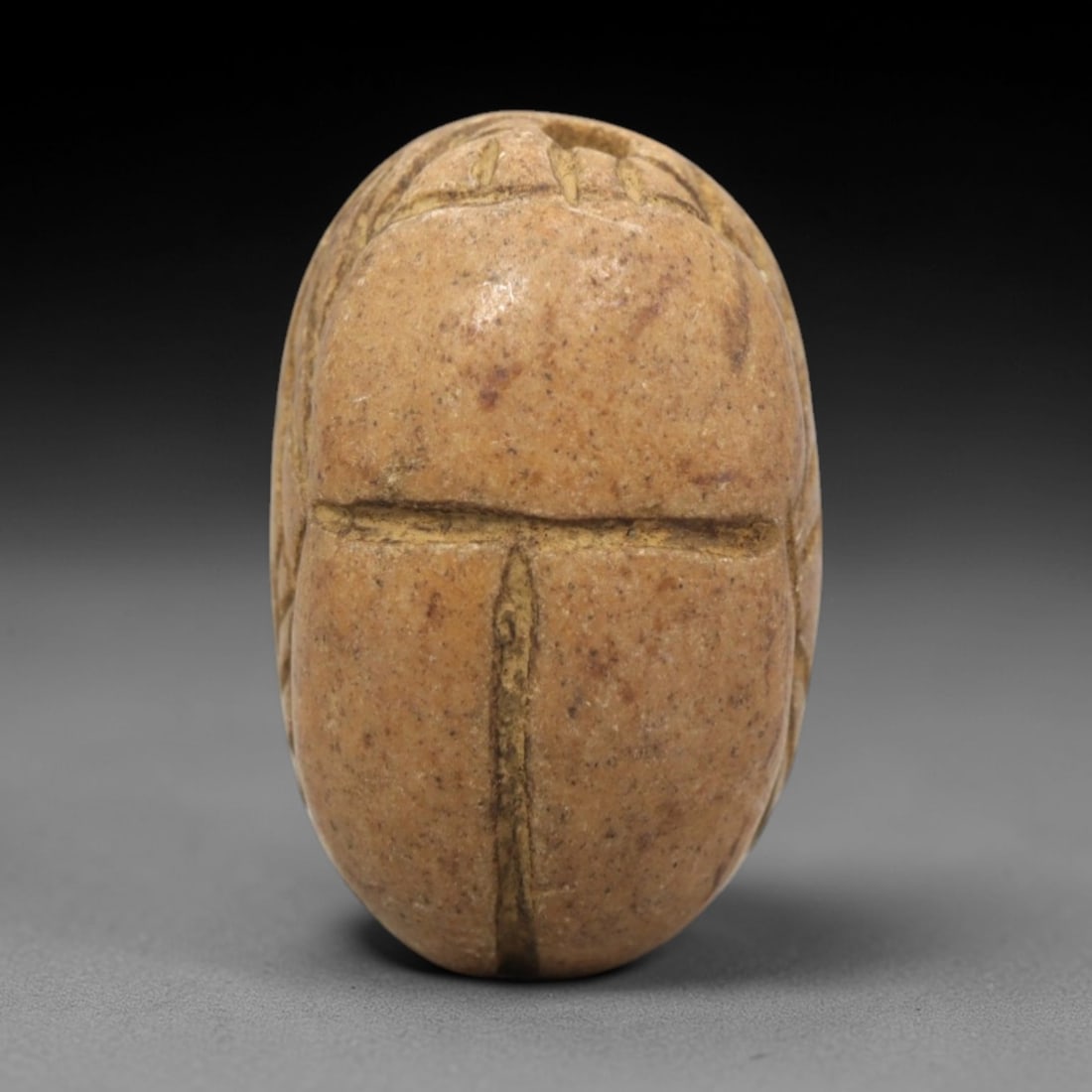 Ancient Egyptian Stone Scarab - Amulet Figurine, 50ZR: This artifact is a carved steatite scarab amulet, crafted from a fine-grained, light tan steatite stone with subtle mottled inclusions and a smooth, worn surface. The dorsal side features deeply incis