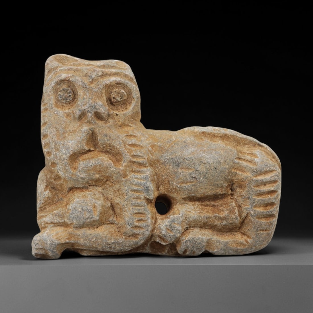 Ancient Stone Lion Figurine - Near Eastern Amulet, 35AH: Carved from stone, this ancient Near Eastern lion figurine features a stylized facial rendering with distinct eye and facial details, crafted in the primitive yet expressive style typical of regional