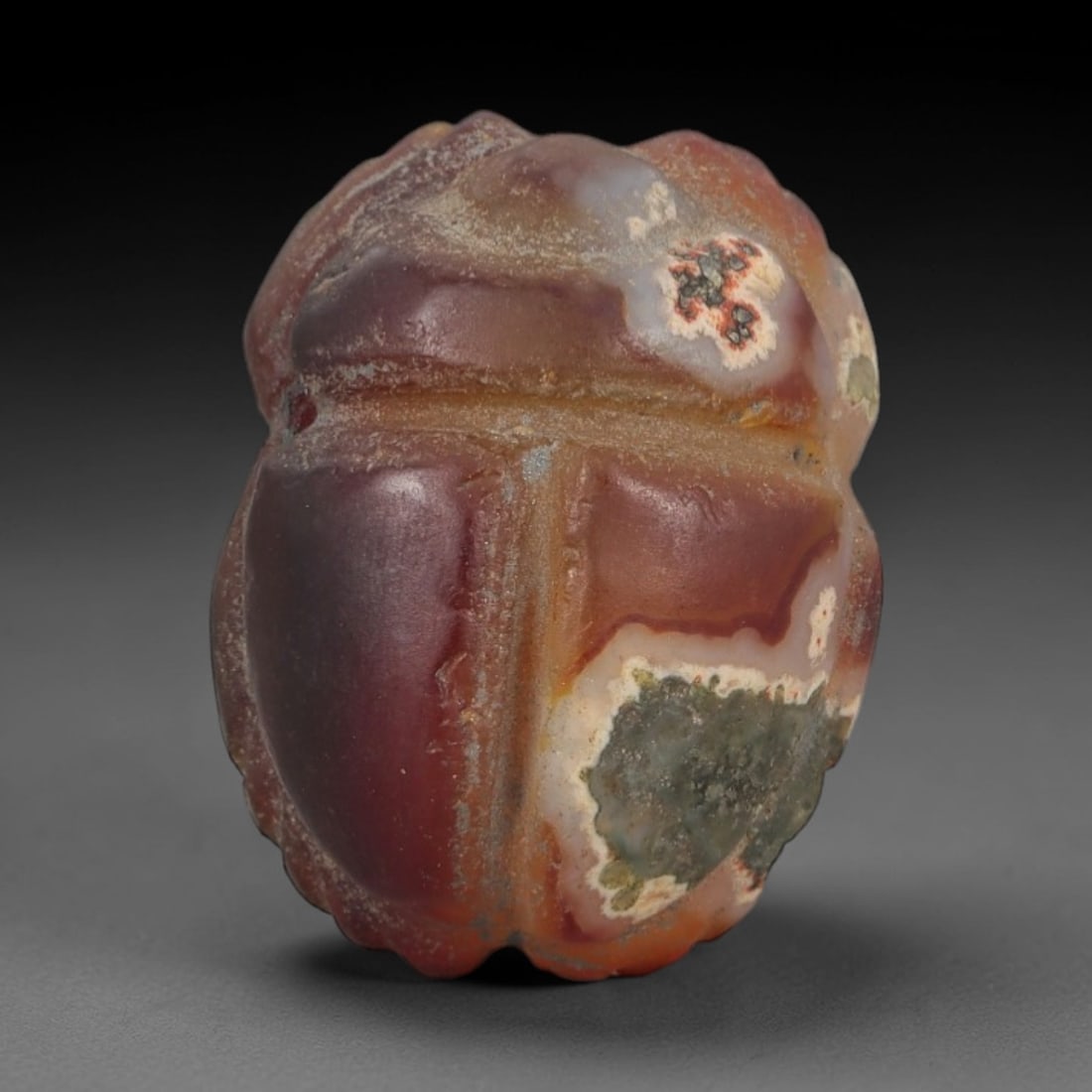 Ancient Banded Agate Scarab Amulet - Egyptian Figurine, 71AJ: Carved from striking banded agate with deep red-brown, creamy white, and mossy green natural inclusions, this amulet is formed as a stylized scarab beetle with incised linear detailing to define segme