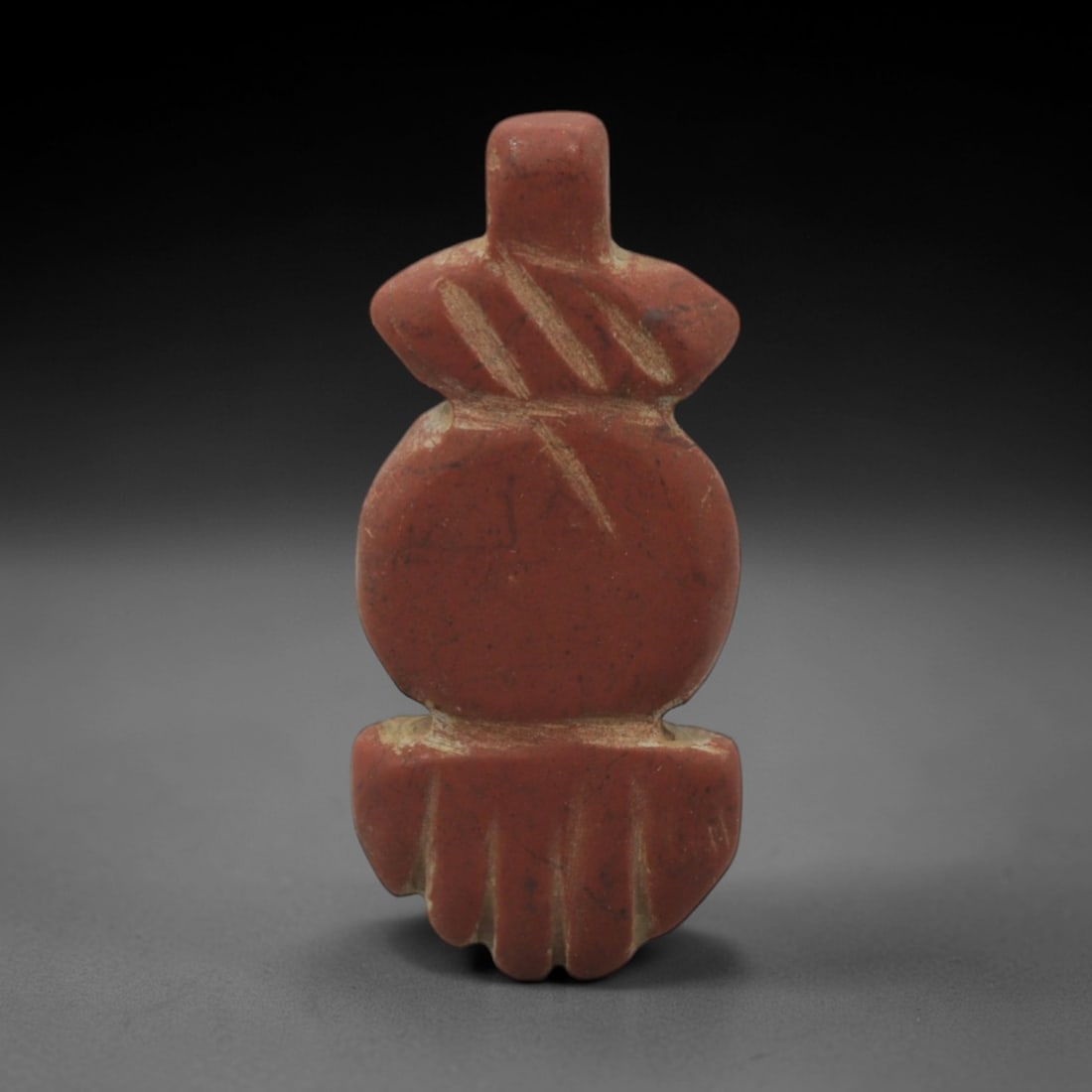 Ancient Stone Floral Amulet - Near Eastern Pendant, 27XR: Carved from rich red stone, this amulet features a stacked geometric design: a rectangular suspension loop at the top, a bulbous middle section with incised linear details, and a lower lobed section