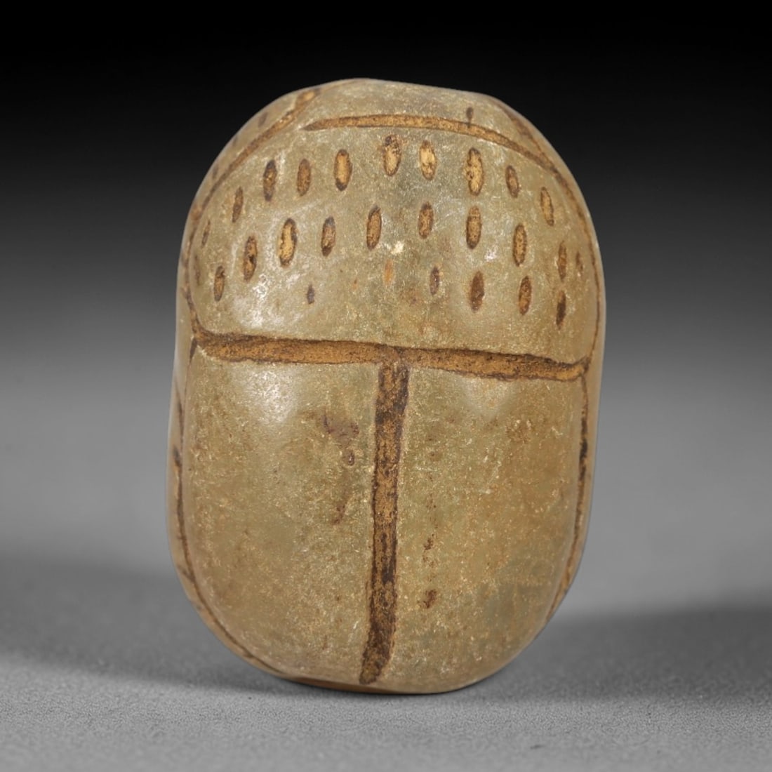 Ancient Egyptian Chalcedony Scarab - Amulet Figurine, 97AL: This artifact is a carved chalcedony scarab amulet, crafted from a fine-grained, pale greenish-grey chalcedony with a smooth, polished surface and warm earthy patina filling the incised decorative