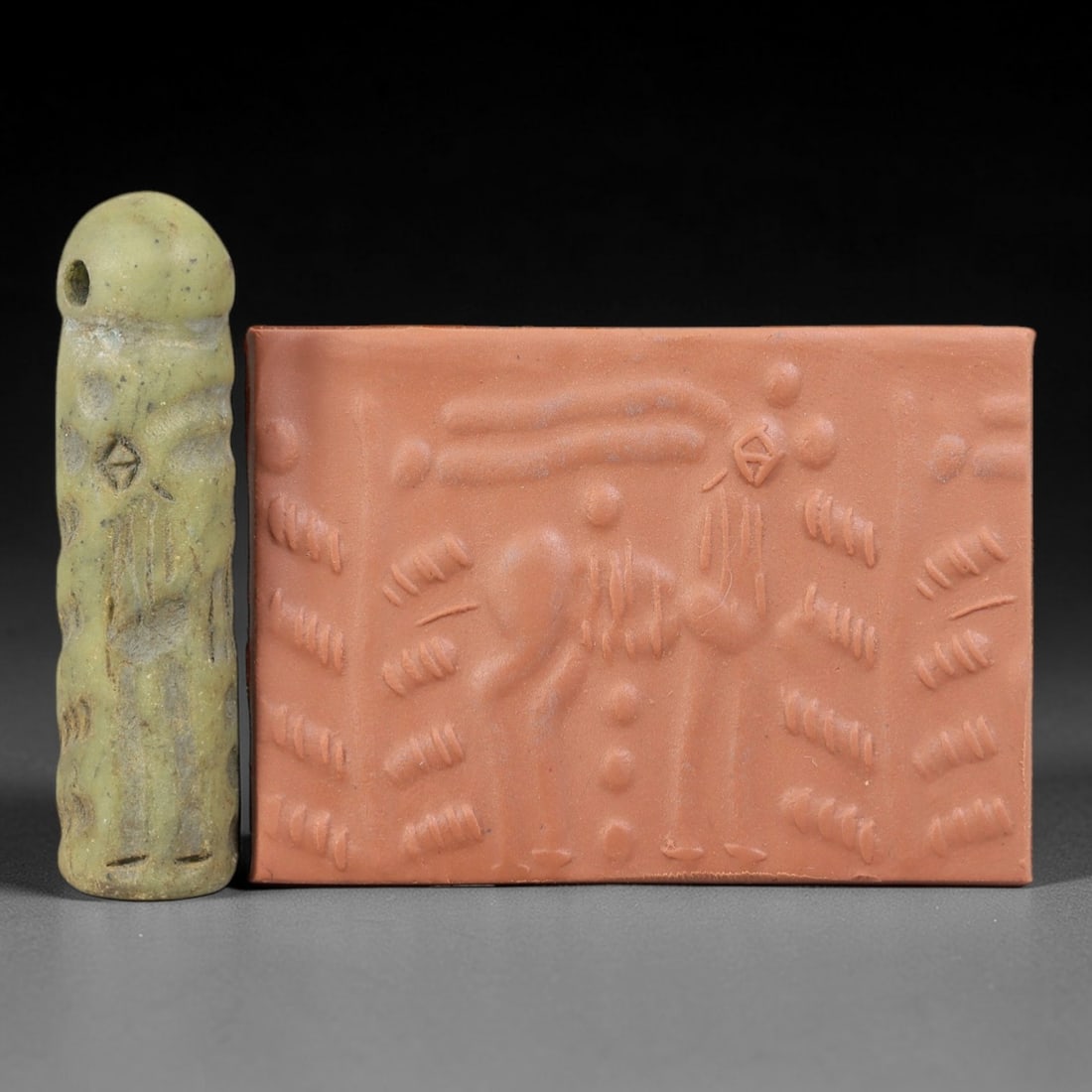 Ancient Serpentine Cylinder Seal - Mesopotamian Ibex & Tree, 66FX: Carved from serpentine, this cylinder seal follows the classic cylindrical form of ancient Mesopotamian administrative and ritual artifacts. Its surface bears a detailed figural scene, featuring two i